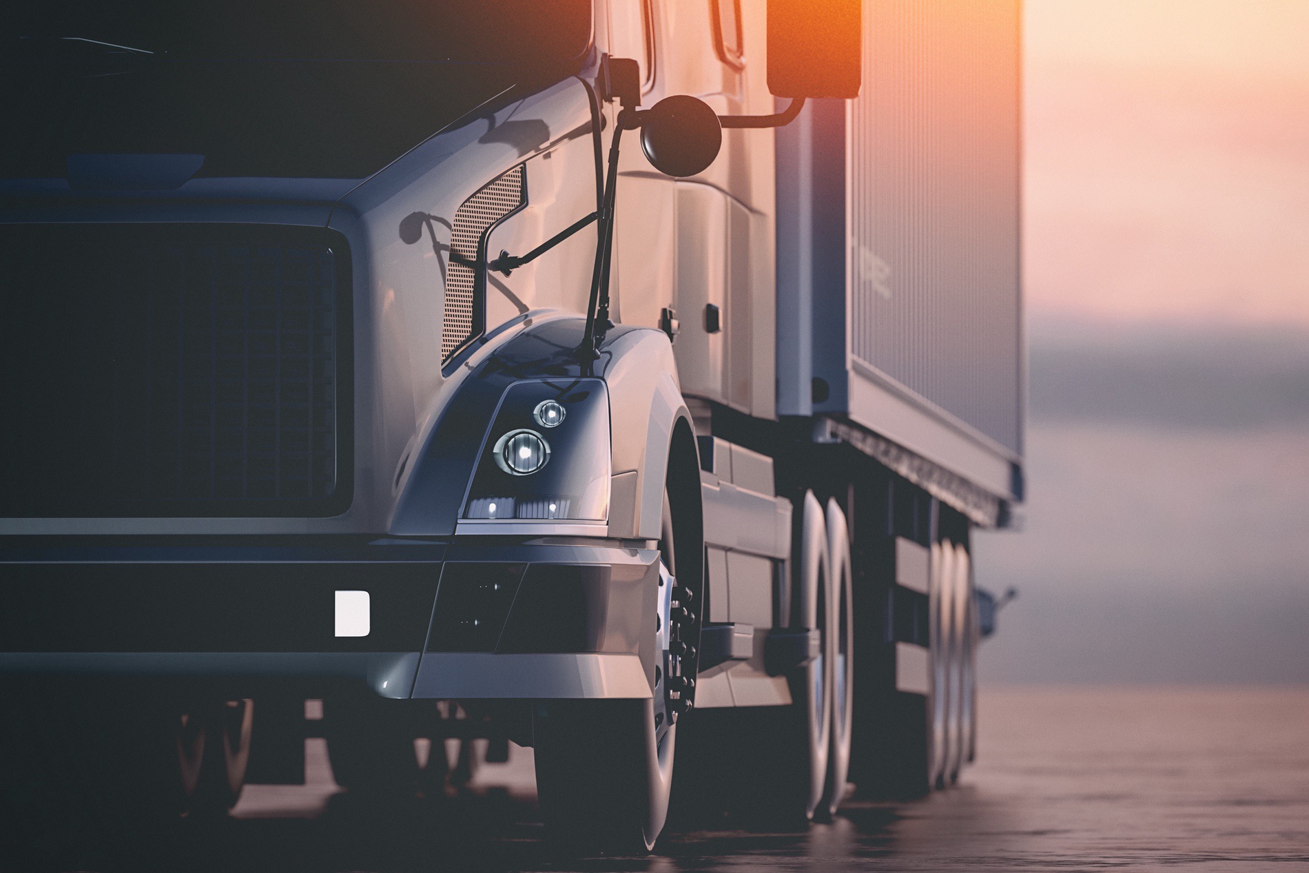 The sunrise shining on the side of a diesel truck