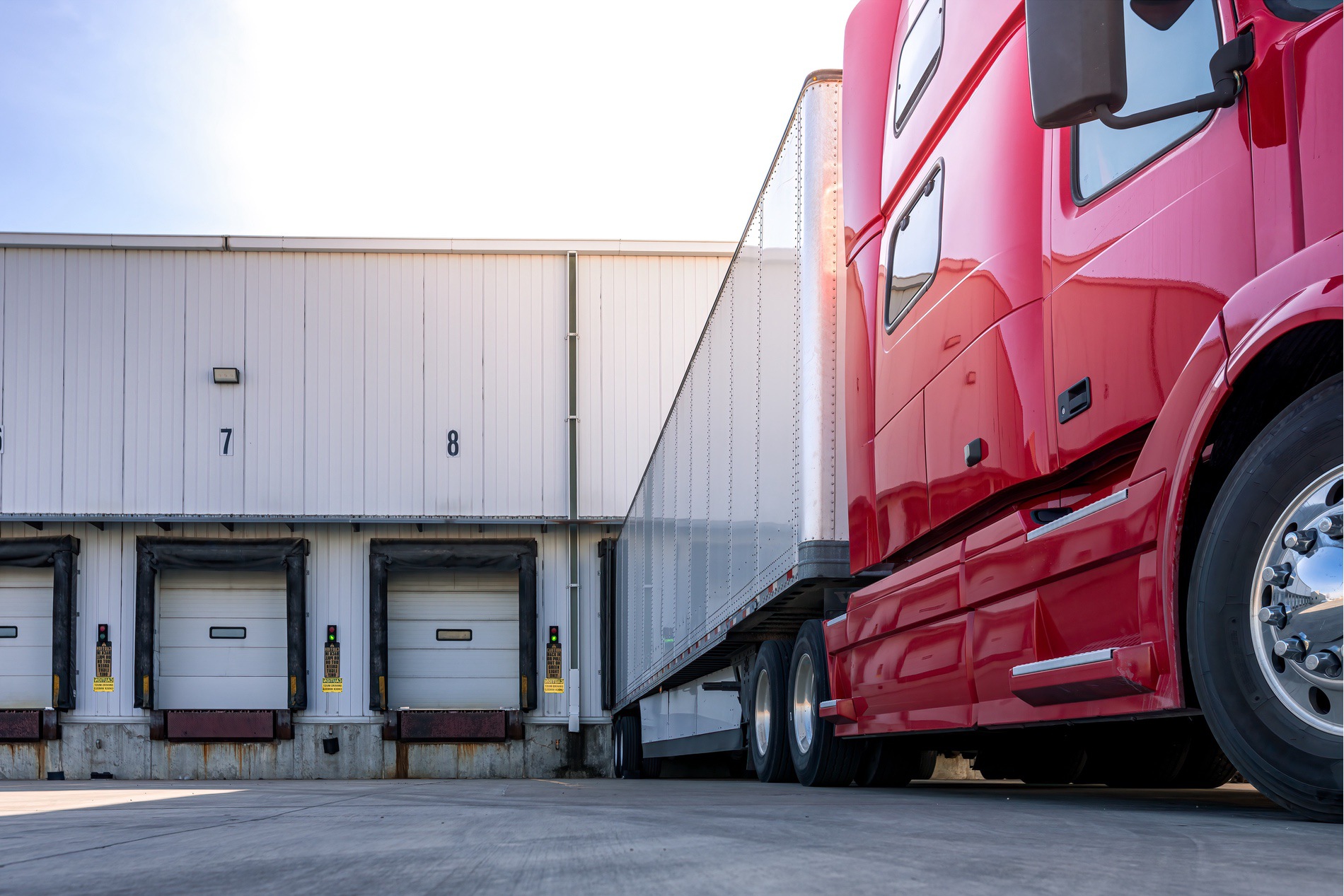 A diesel truck sitting at a delivery bay waiting to be unloaded. 