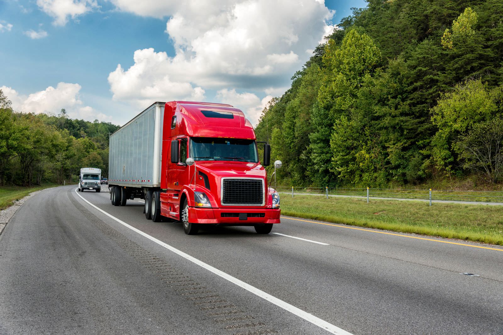 a red semi-truck driving down a highway