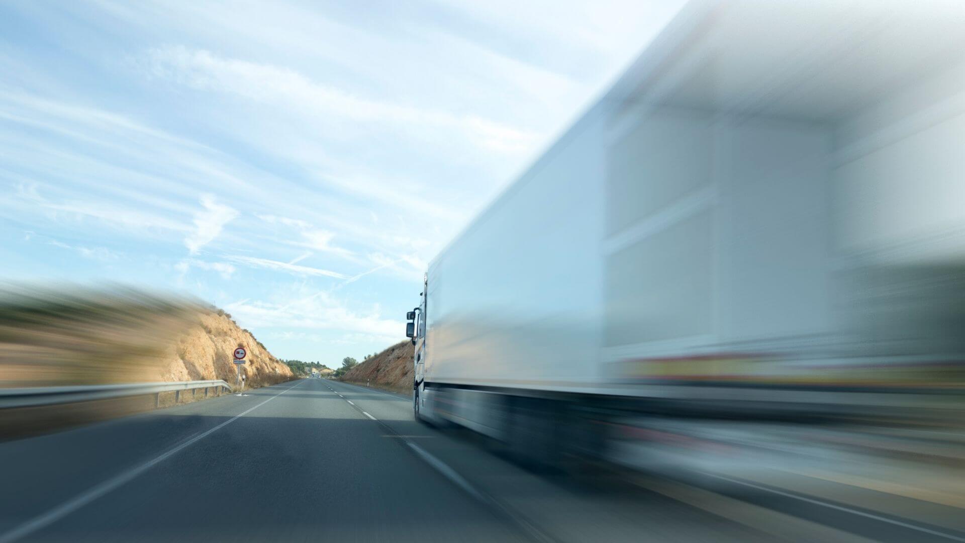 Commercial truck driving on highway representing trucking insurance in Stockton